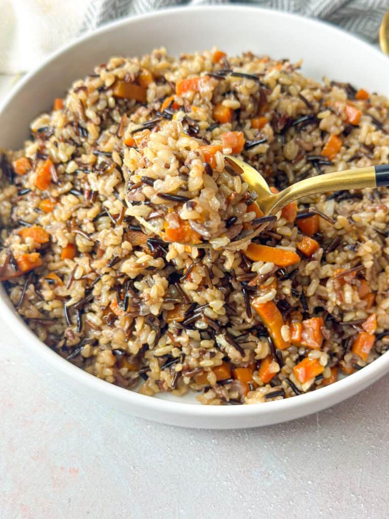 a spoonful of wild rice with onions and carrots