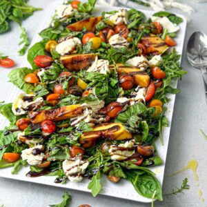 grilled peaches, creamy burrata, and peppery arugula combine for a culinary masterpiece that's both delicious and visually stunning.