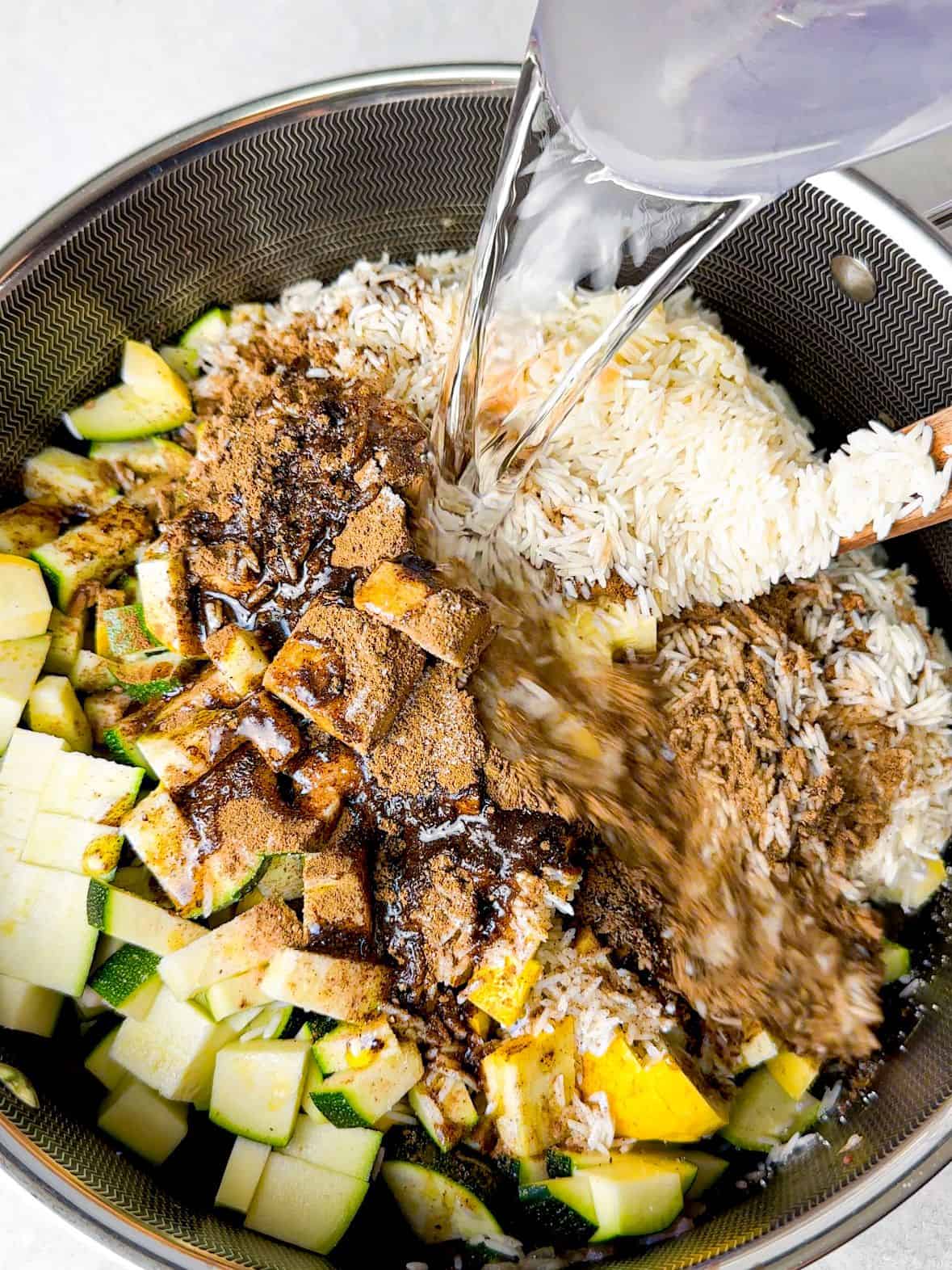 water added on ground beef, squash cubes, sauteed ground beef, onions, and spices