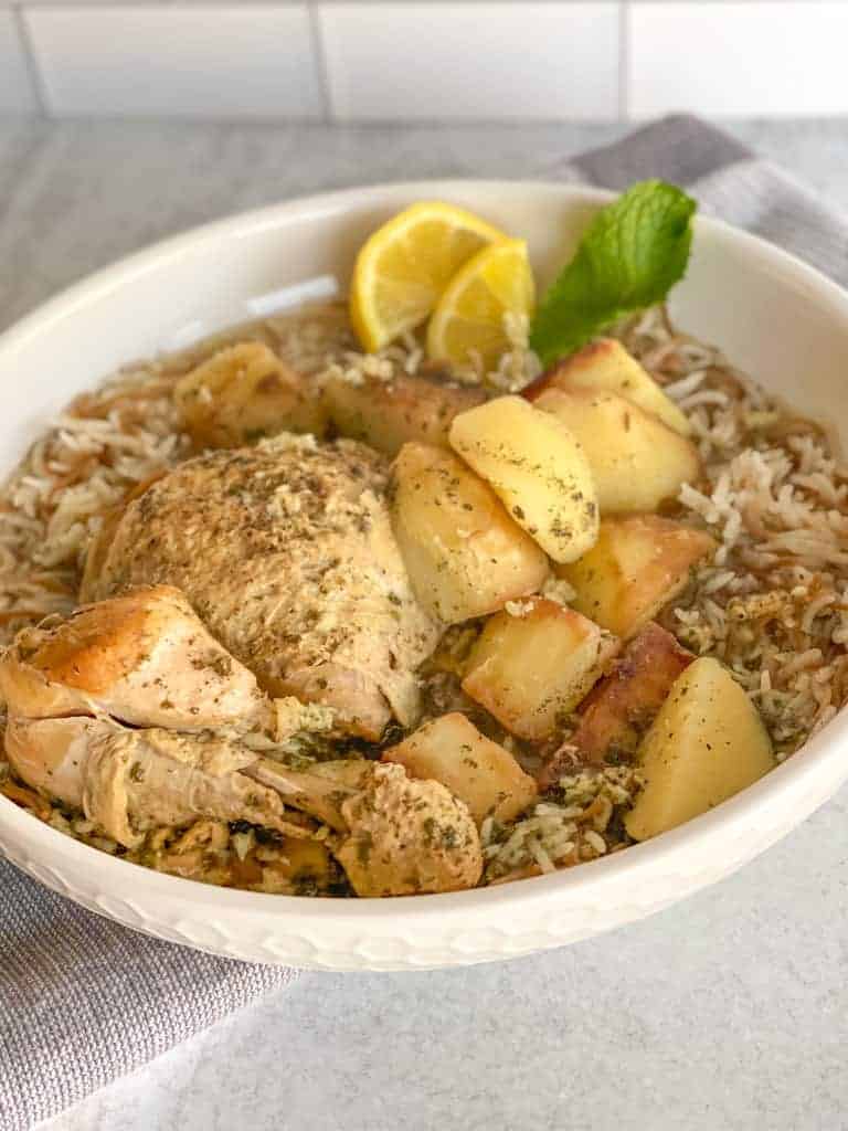 a hearty bowl of vermicelli rice topped with potato and chicken lemon garlic stew