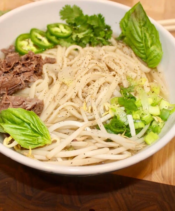 A steaming bowl of Vietnamese Pho soup.