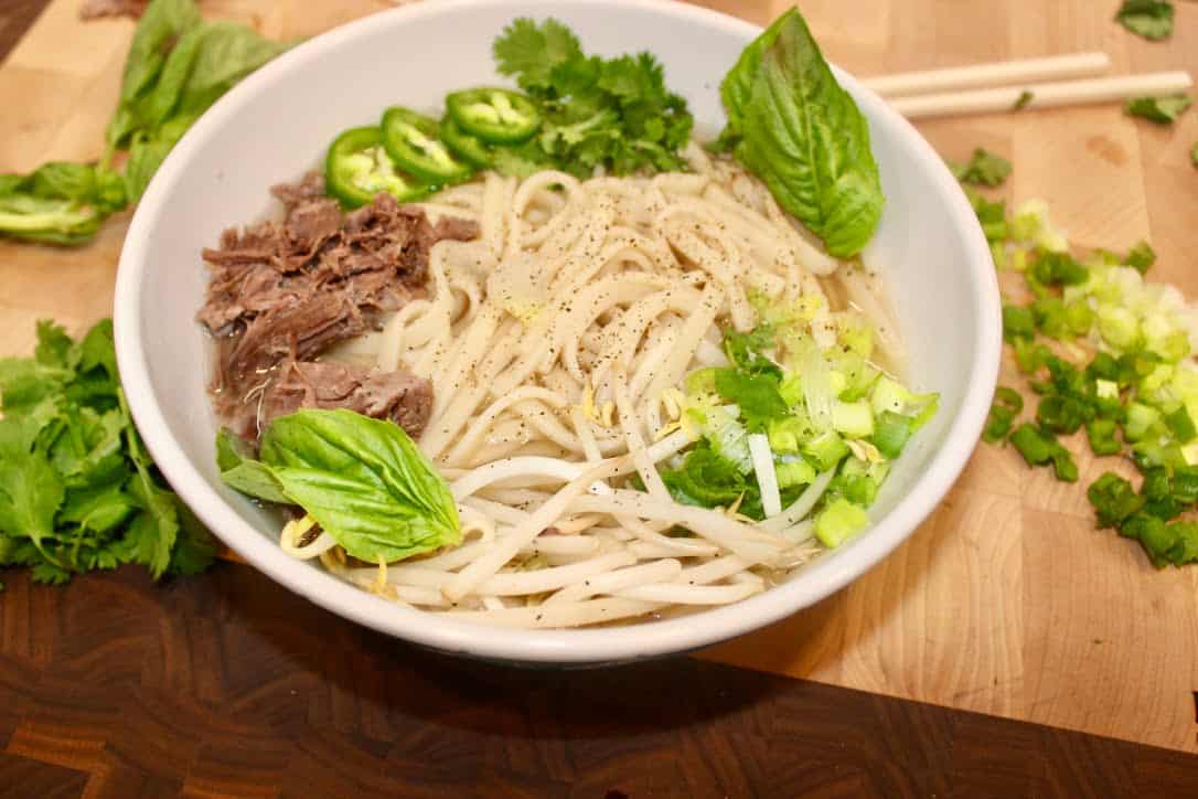 A steaming bowl of Vietnamese Pho soup.