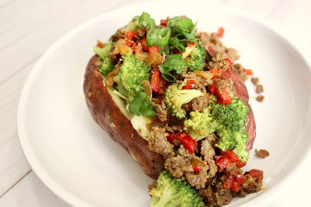 A medium sweet potato with broccoli and beef with garlic, onion, and red bell pepper and s seasoned with chili powder, ground cumin, and salt