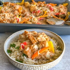 Cheesy Cajun Chicken Potato with colored peppers Boats in a pan on top of rice