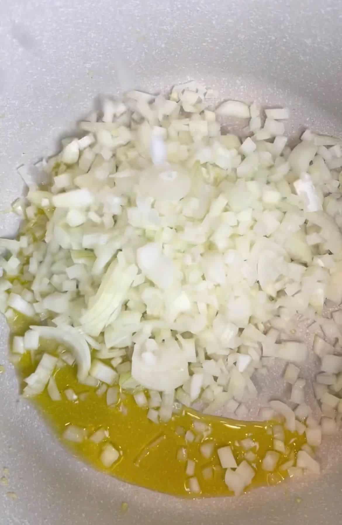 Some oil and cubed onions in a skillet.