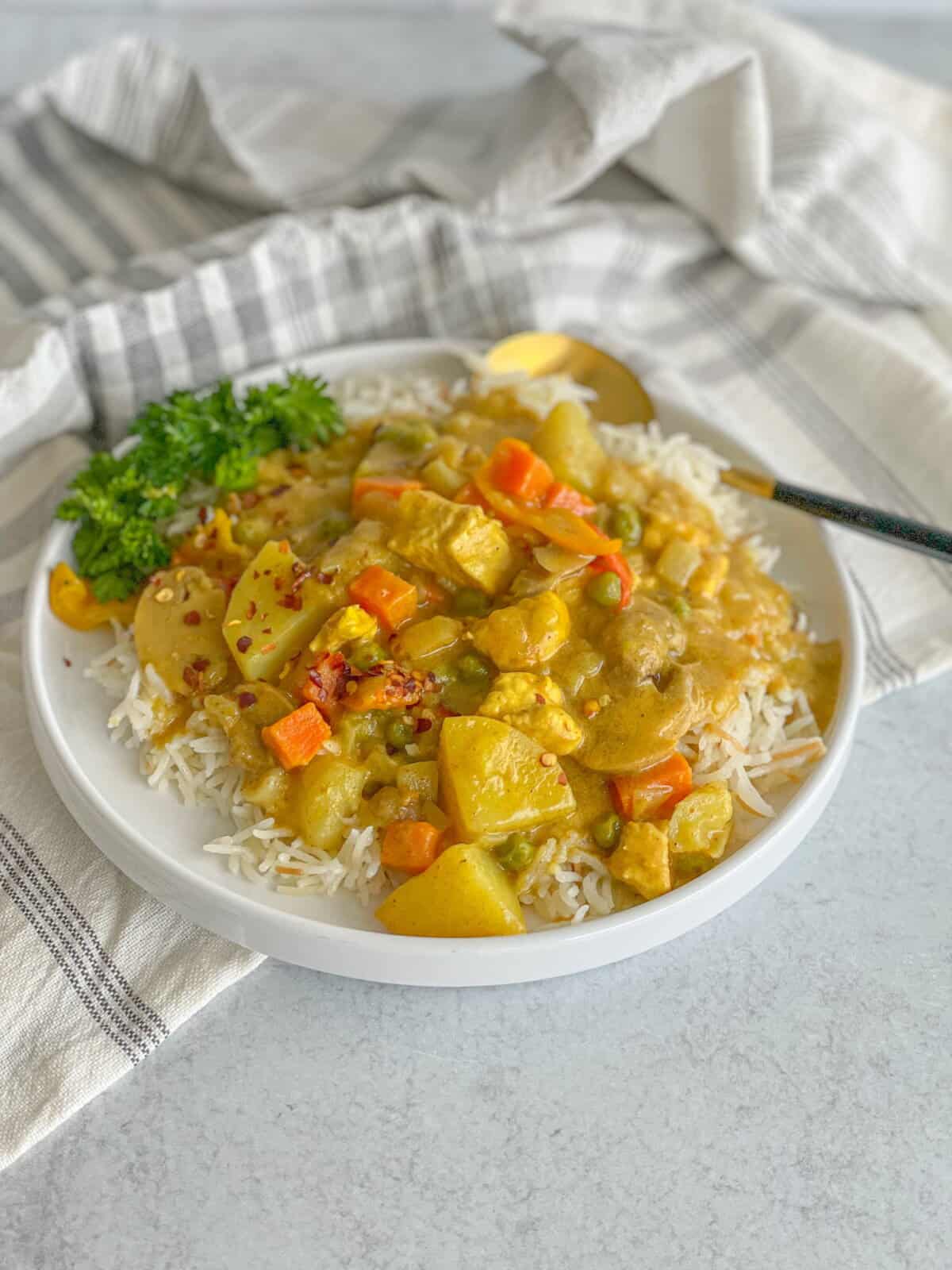 Creamy Chicken Vegetable Curry a dish of warm creamy chicken vegetable curry recipe served on a bed of white rice and sprinkled with chili flakes