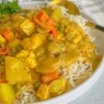 chicken curry with vegetable dish served on a bed of white rice