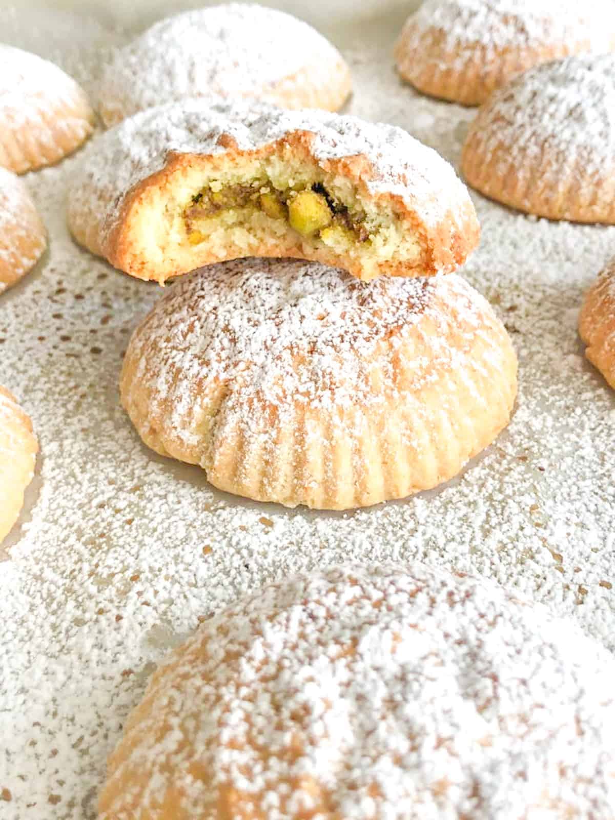 Lebanese Maamoul cookies filled with pistachios and topped with powdered sugar.
