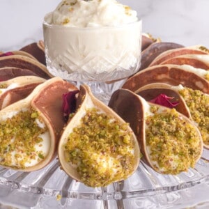 Atayif or Middle Eastern pancakes stuffed with quashta and dipped in ground pistachios