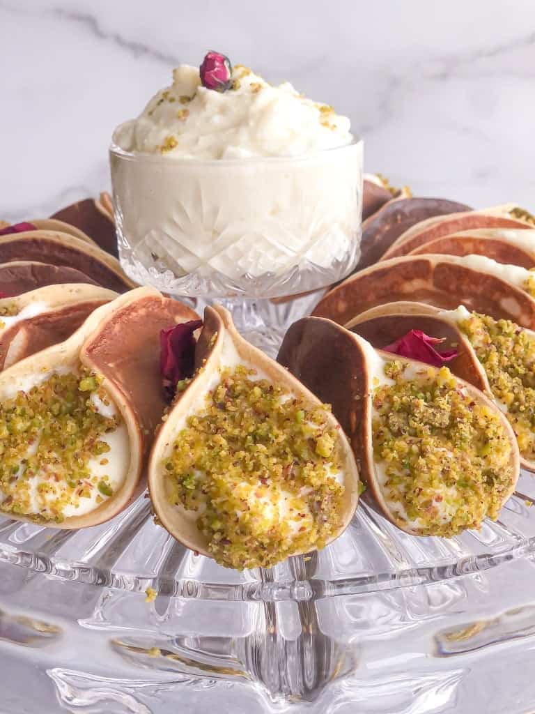 Atayif or Middle Eastern pancakes stuffed with quashta and dipped in ground pistachios