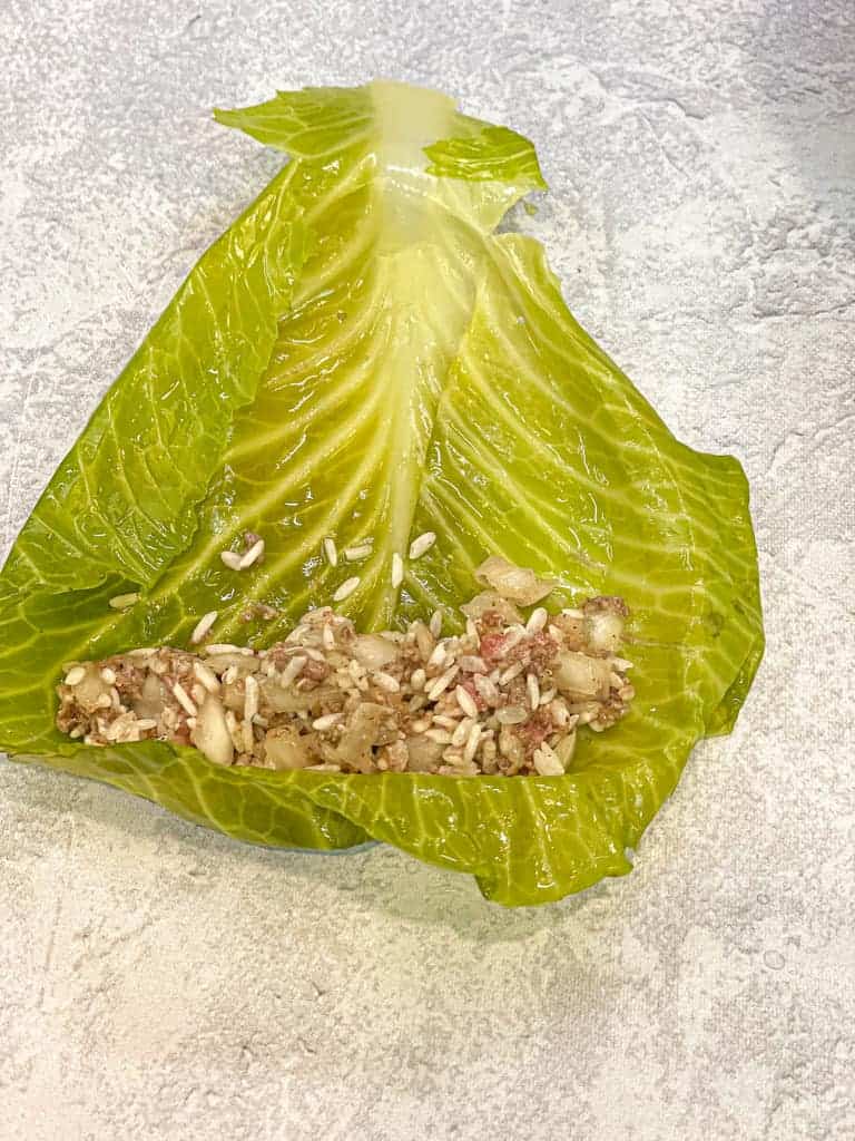 a single cabbage leaf (malfoof) with the stuffing mix added to the top wider side of the leaf before folding