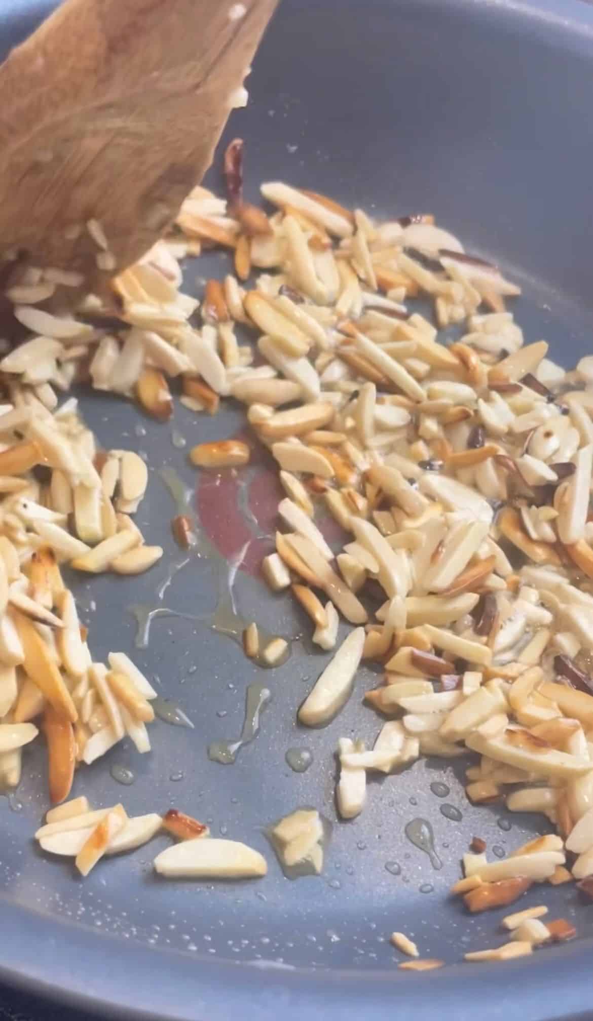 Nuts being tossed in melted butter until golden.