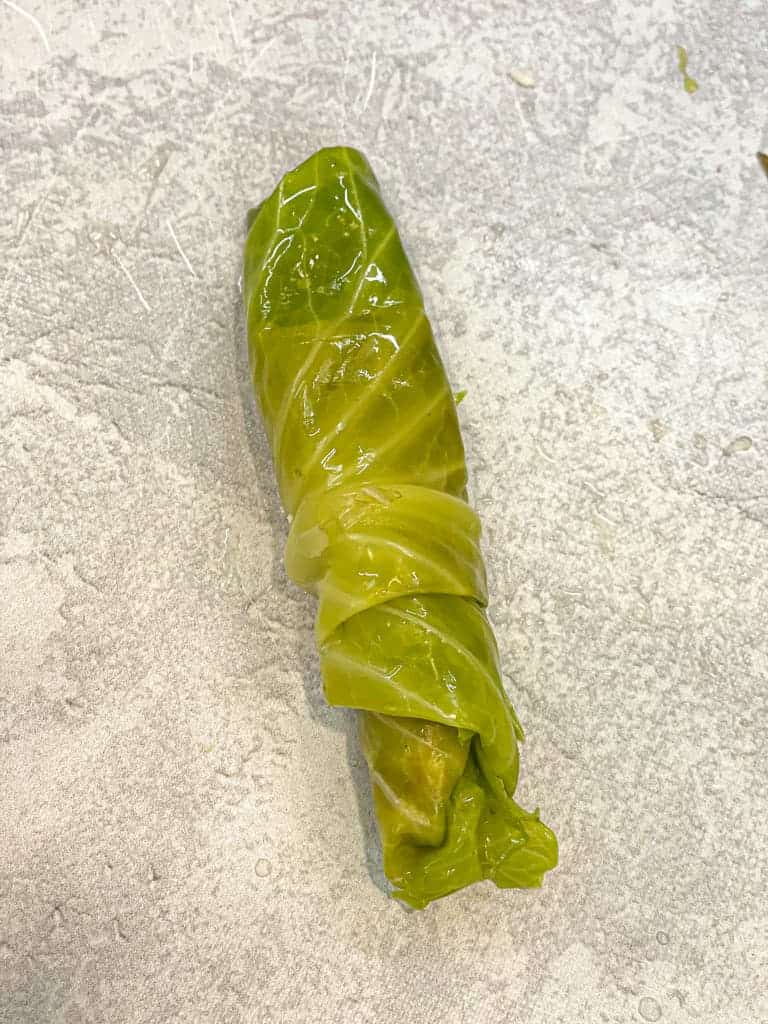 a single cooked cabbage leaf (malfoof) fully rolled with stuffing inside