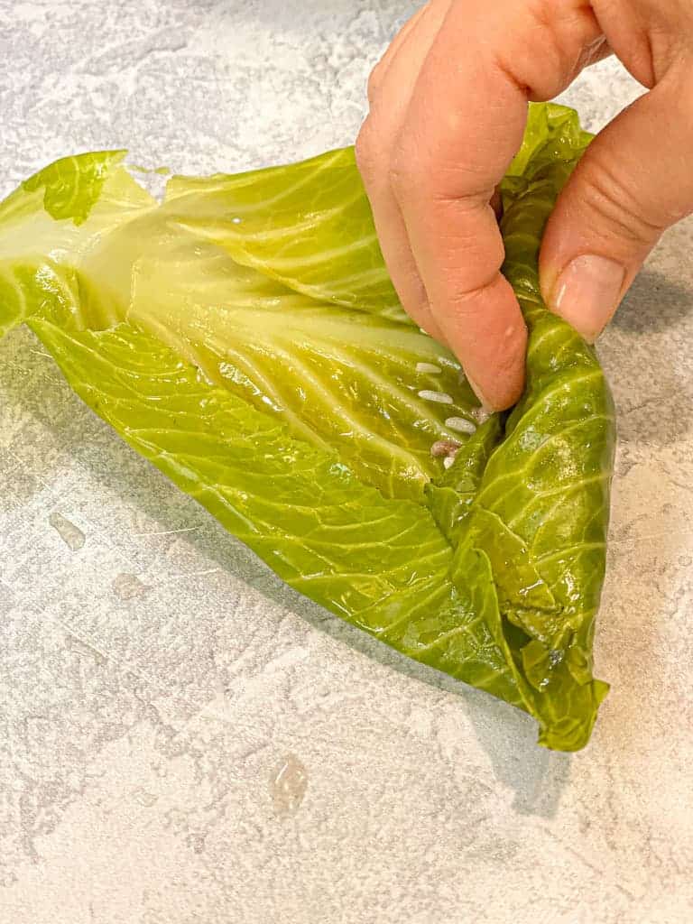 the first step in actually rolling the cabbage leaf (malfoof) with the stuffing inside
