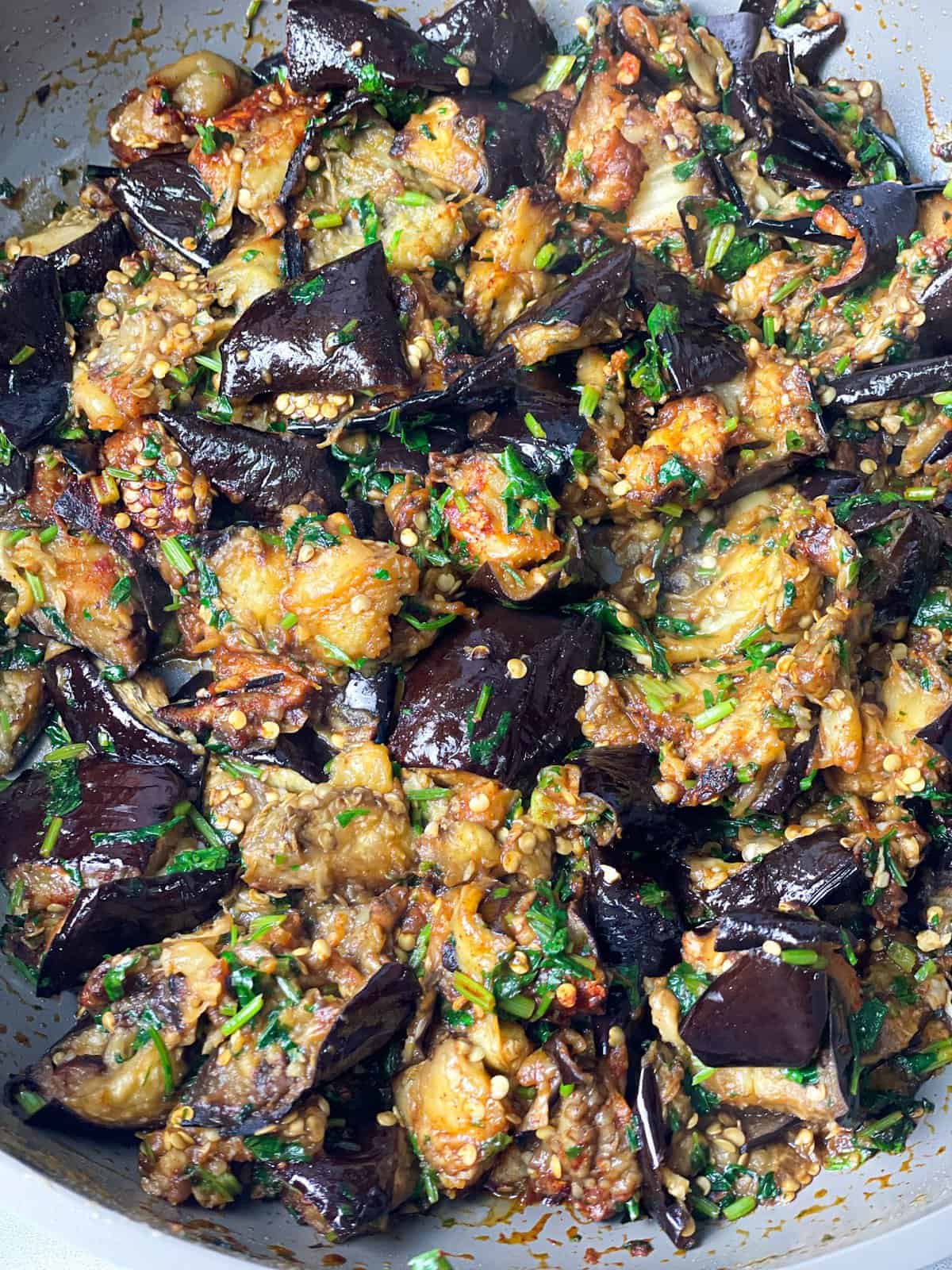 a pan of baked eggplants cut into cubes and sauteed with some cilantro and garlic
