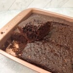 The photo captures a side view of cake, featuring a mini slice cut from the cake with a visible bite taken.