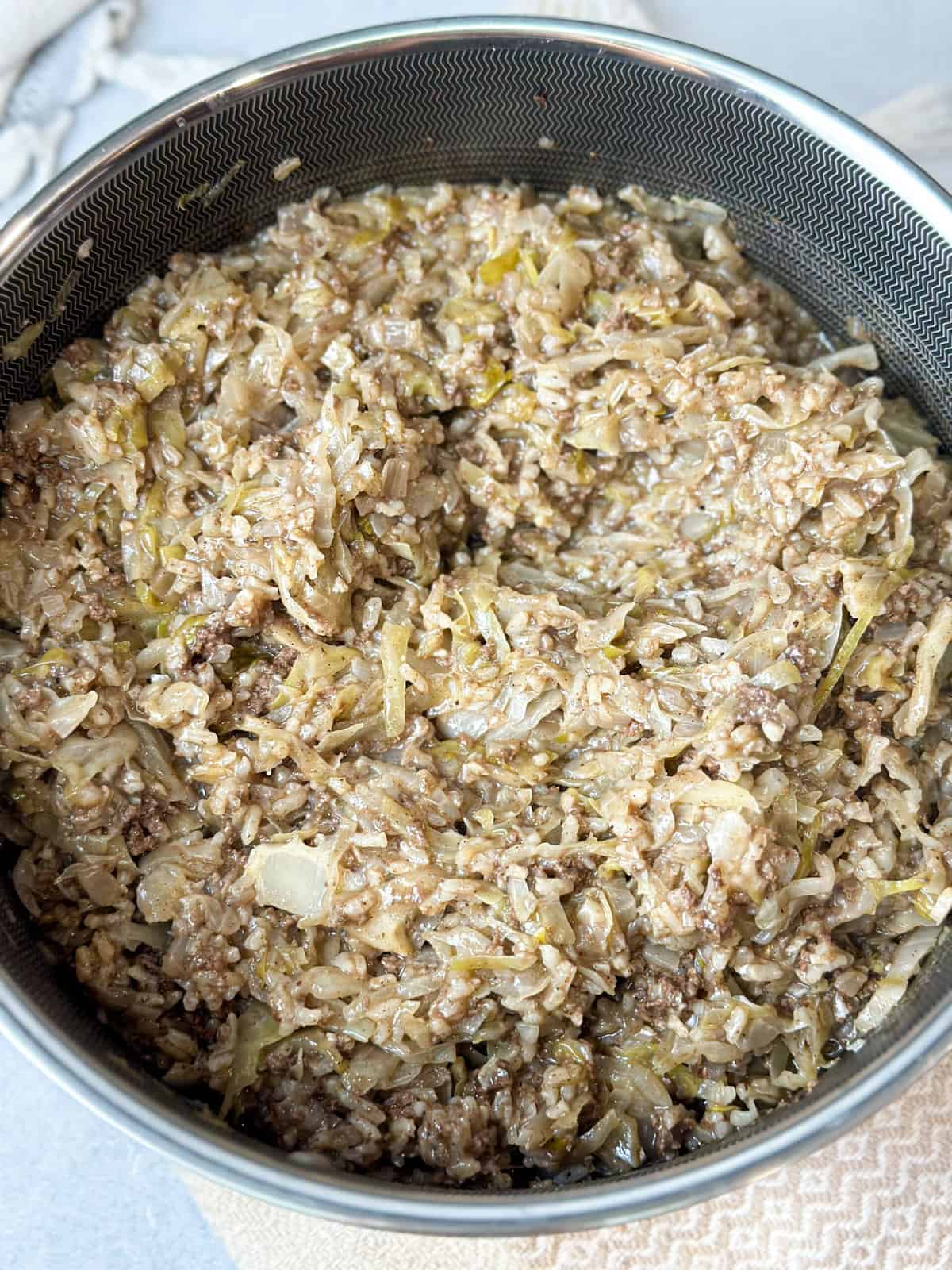 a top view of a pot of unstuffed cabbage (malfoof) with rice and ground beef