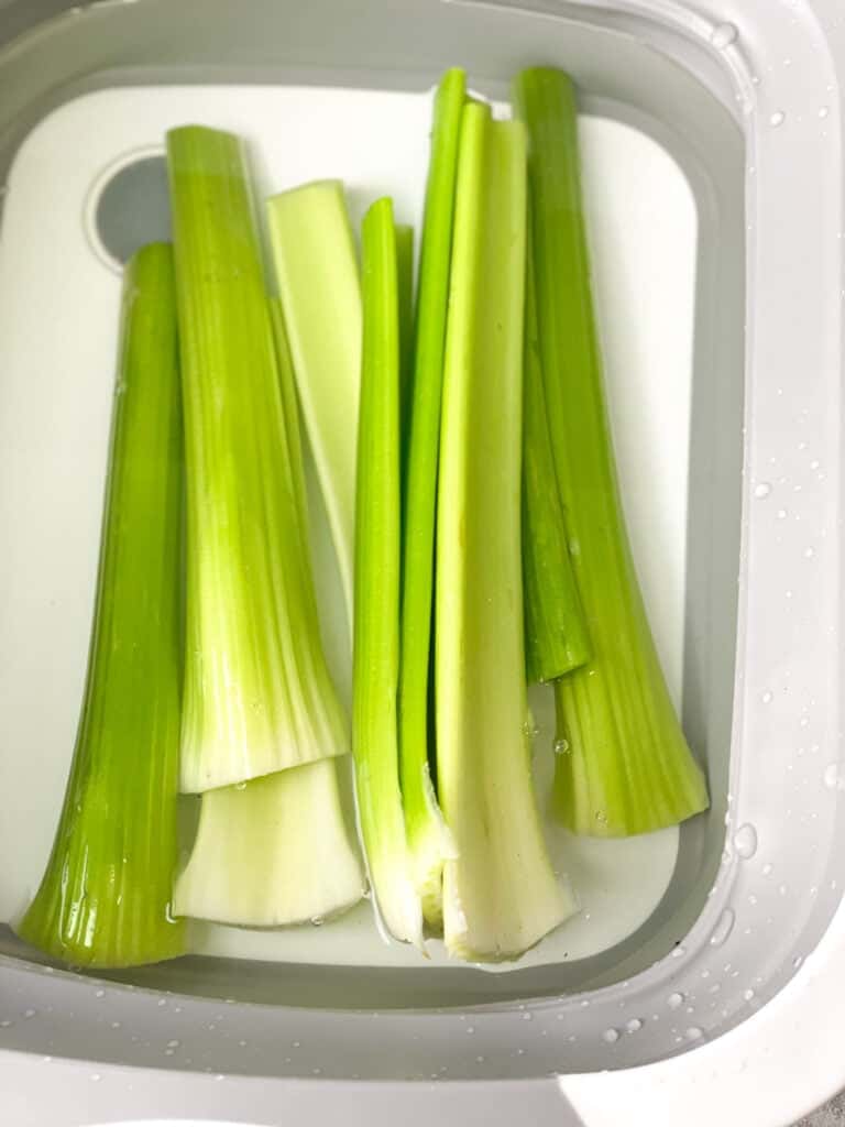 clean and fresh celery stalks in a plastic container