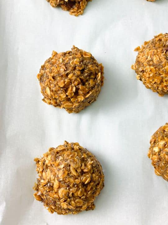 Pumpkin spice energy balls with chocolate chips placed on a parchment paper.