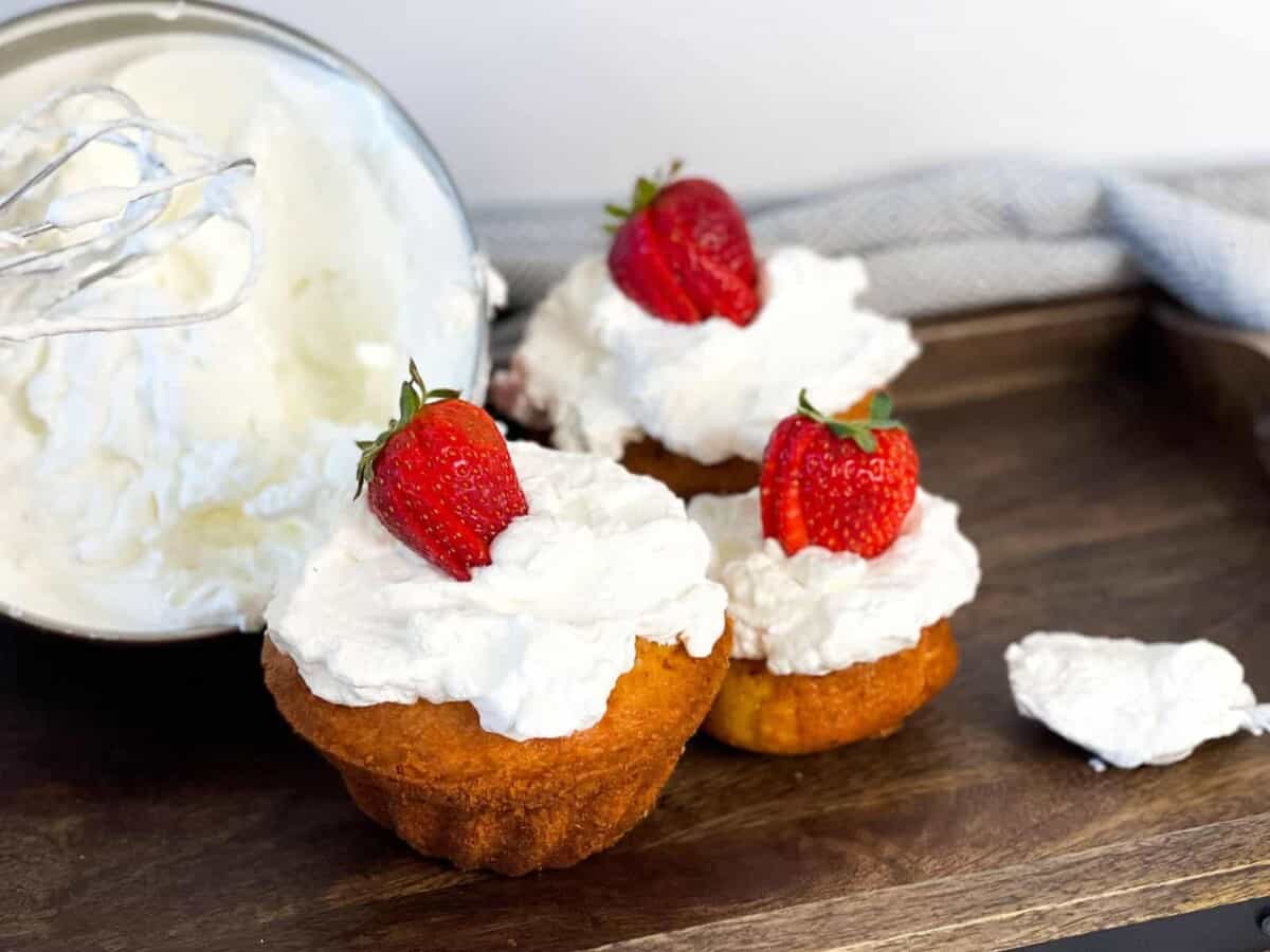 Cupcakes topped with homemade caramel macchiato whipped cream and strawberries.