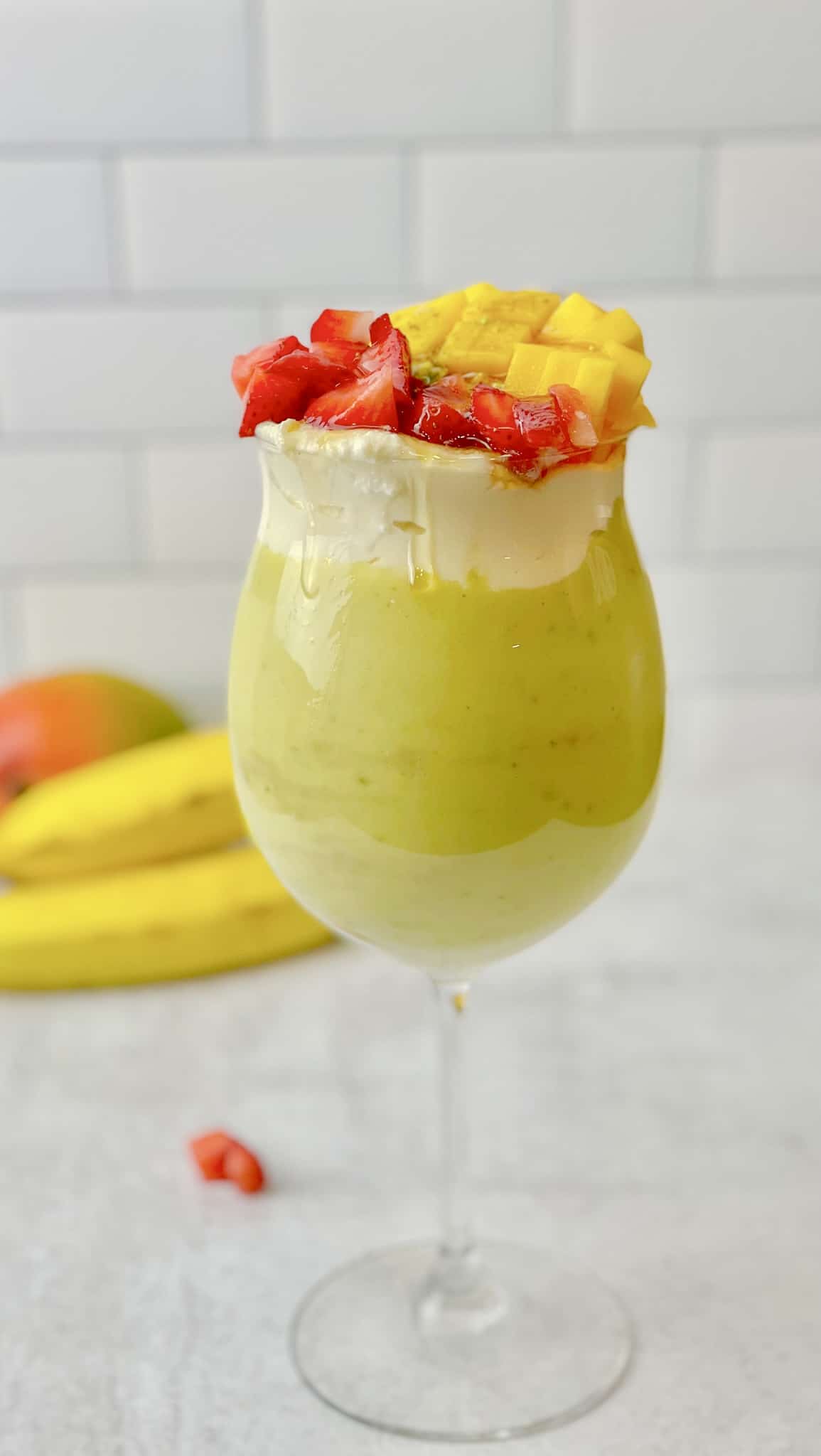 A tasty cool avocado smoothie topped with strawberries and mangoes.