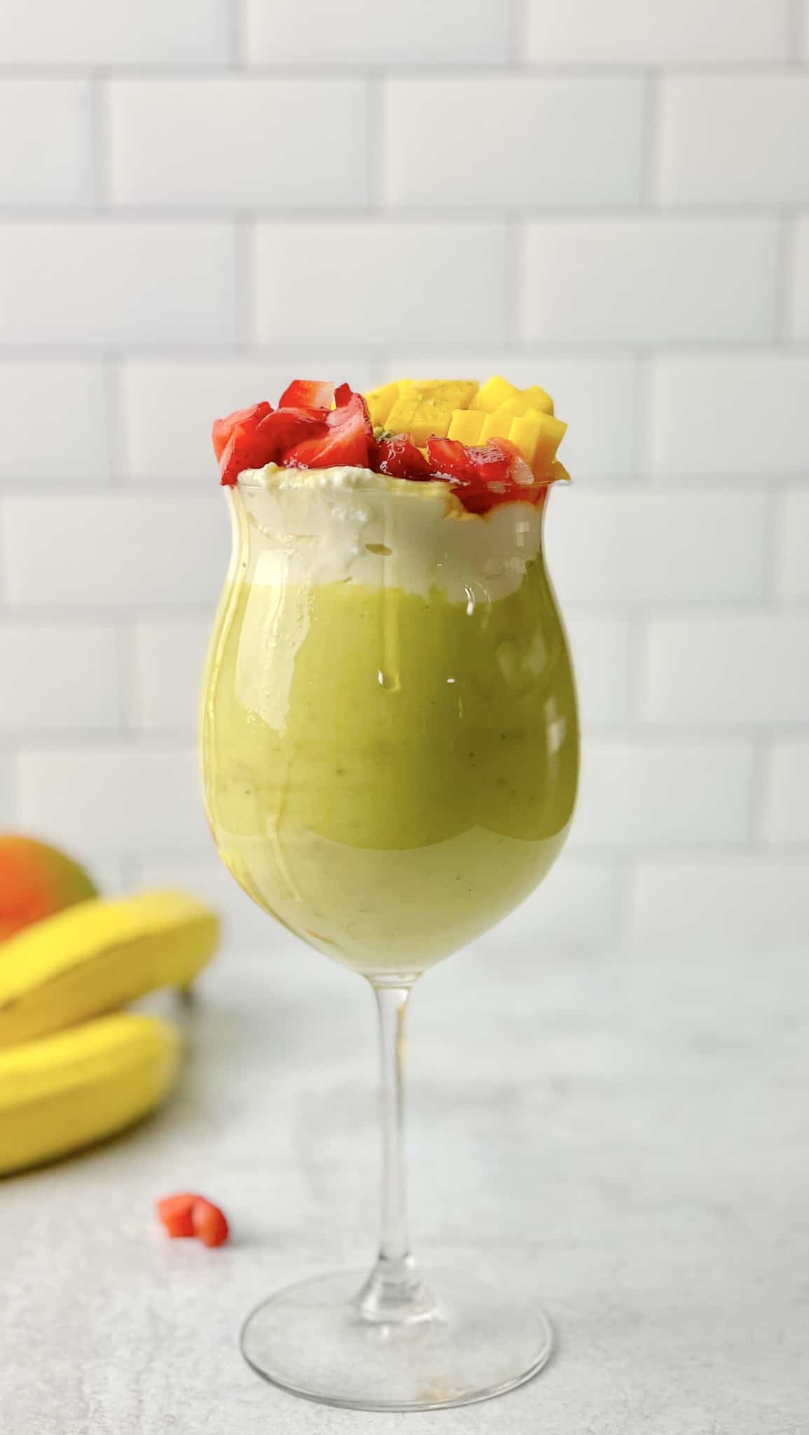 A nice cup of avocado smoothie topped with delicious fruits.