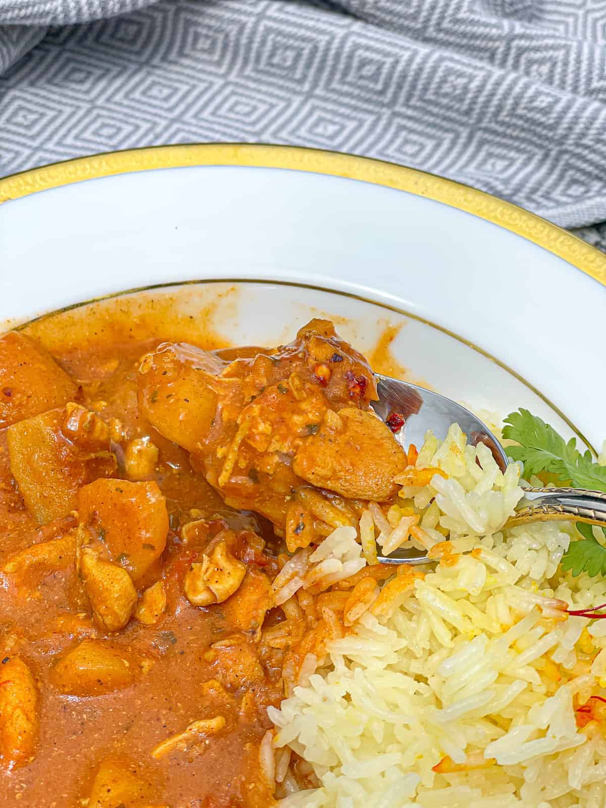 a spoonful of healthy chicken tikka masala and rice