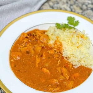a plate of Chicken Tikka Masala with Coconut Milk next to white rice