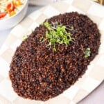 A top view of a plate of mujadara hamra served next to a bowl of cabbage salad
