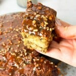 Sticky Date Pudding topped with a rich butterscotch sauce, garnished with a sprinkle of walnuts