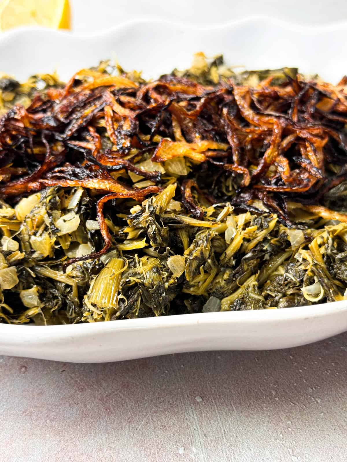 Close-up of Lebanese dandelion greens salad and served on a white plate.