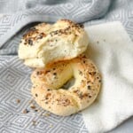 Freshly baked gluten-free bagels on a kitchen towel, golden and crisp