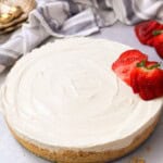 a shot of no-bake cheesecake with a crunchy crust and cheesecake filling with sliced fresh strawberries on top