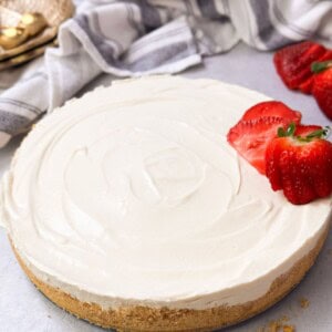 a shot of no-bake cheesecake with a crunchy crust and cheesecake filling with sliced fresh strawberries on top