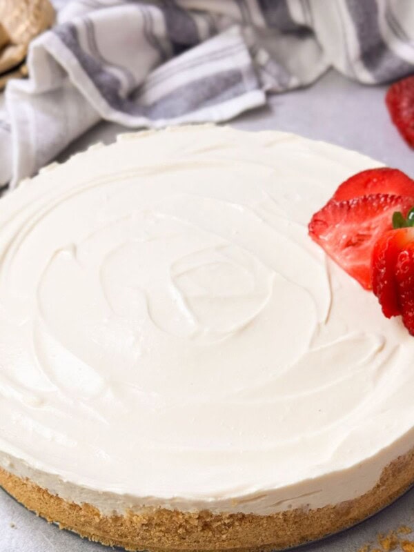 a shot of no-bake cheesecake with a crunchy crust and cheesecake filling with sliced fresh strawberries on top