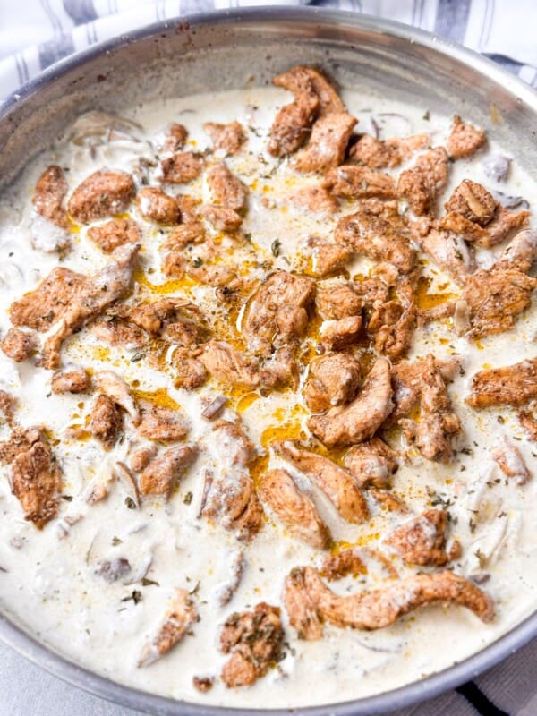 A side shot of tender juicy garam masala chicken submerged in creamy velvety mushroom sauce