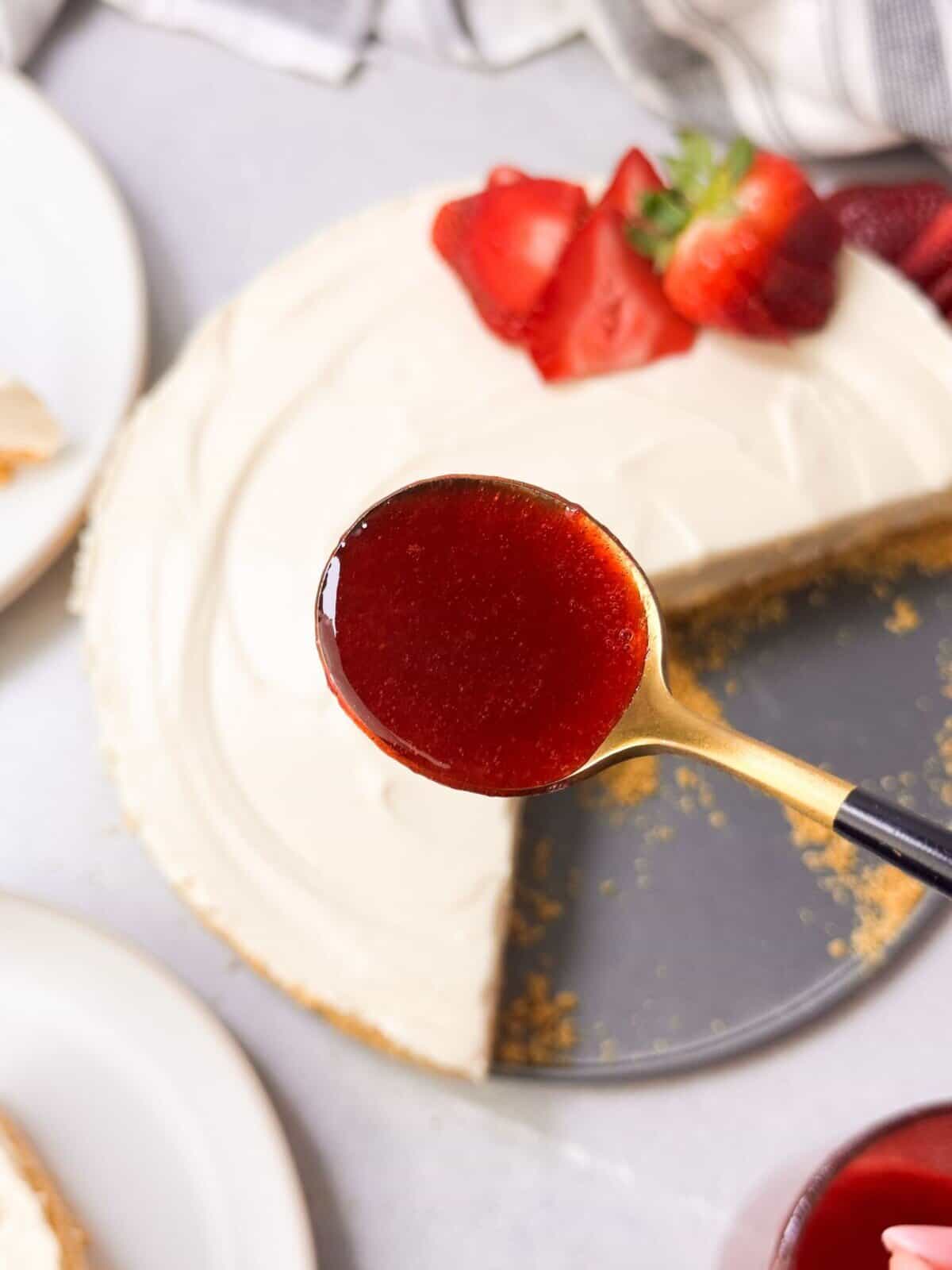 Strawberry Rosemary Sauce a top shot of a spoonful of strawberry rosemary sauce to be drizzled over no bake cheesecake