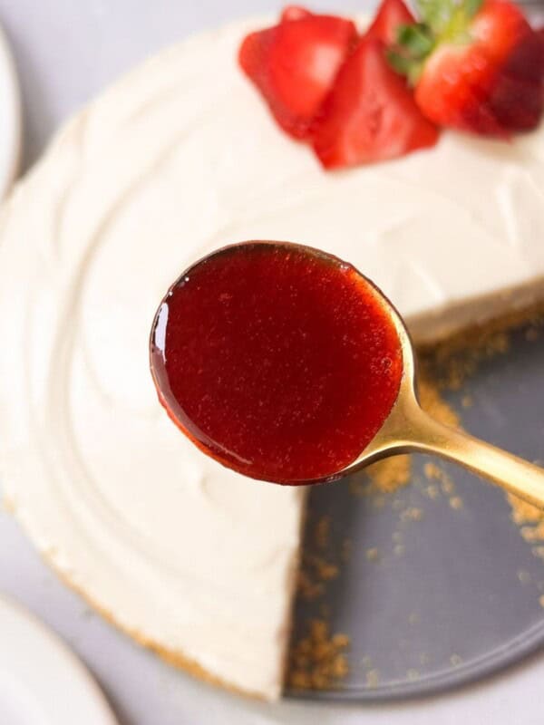 a top shot of a spoonful of strawberry rosemary sauce to be drizzled over no bake cheesecake