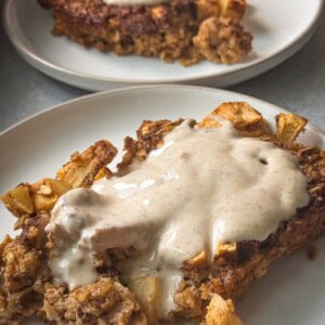 apple cinnamon oatmeal bake topped with yogurt frosting served in a white plate