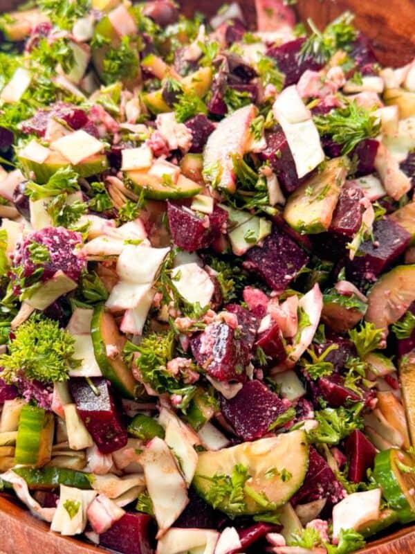 Close-up of colorful beet, cucumber, and feta salad tossed in vinaigrette.