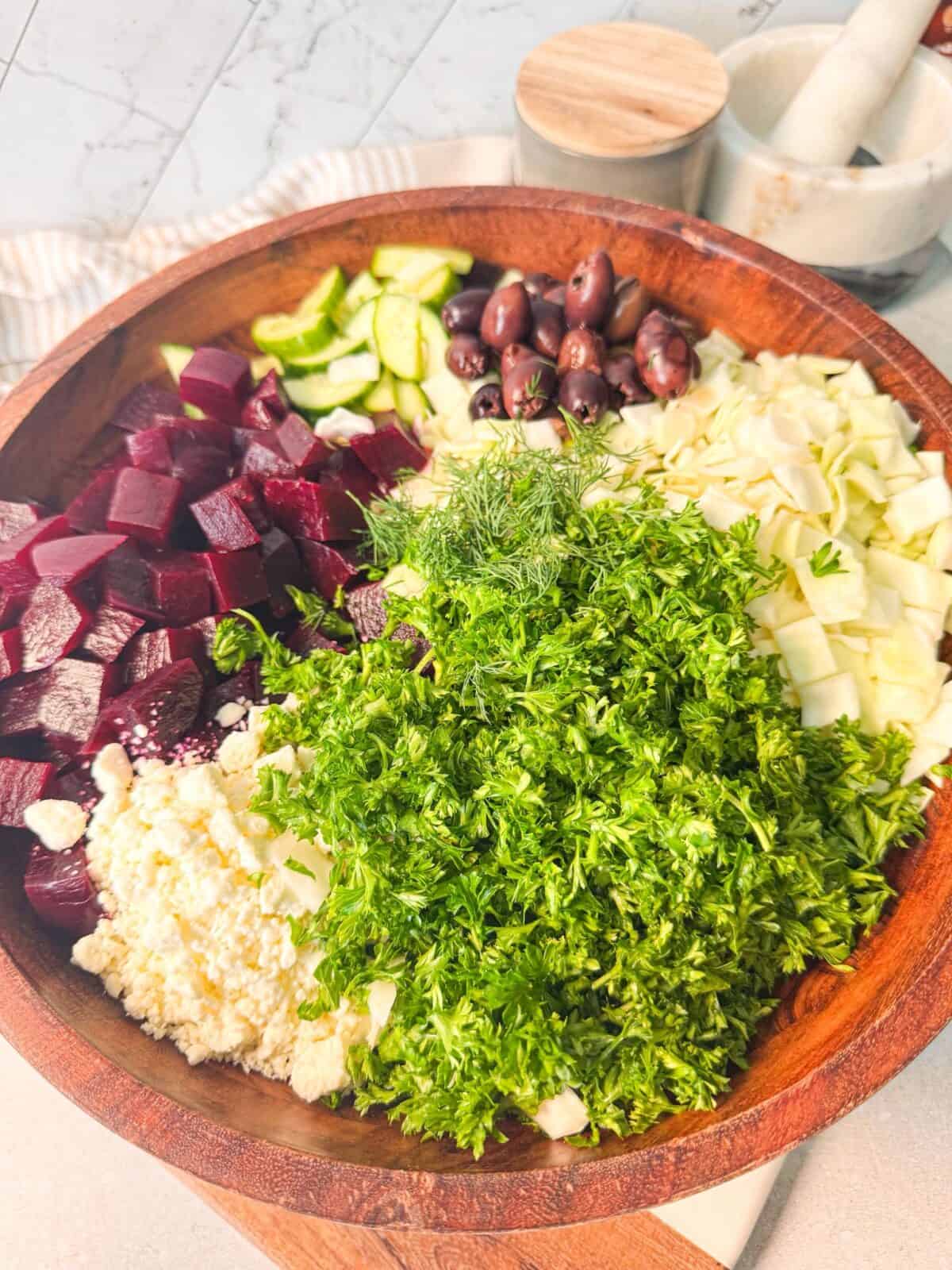 Beet Cucumber Feta Salad Ingredients beet cucumber feta salad ingredients: diced beet, crumbled feta, diced cucumber, Kalamata olives, shredded cabbage, and parsley
