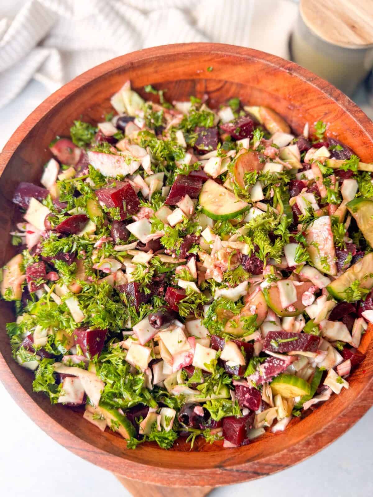 Beet Cucumber Feta Salad Recipe top shot of a wooden bowl filled with beet, cucumber, feta, and parsley salad