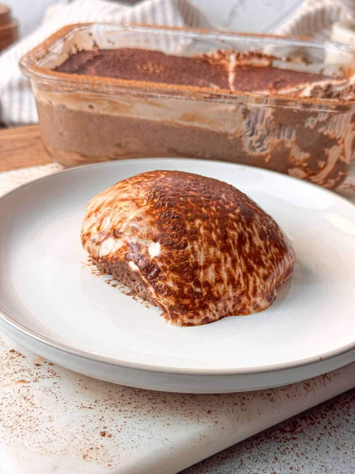 Creamy Mocha Chia Pudding Cake A slice of creamy mocha chia pudding cake served on a white plate, topped with cocoa powder