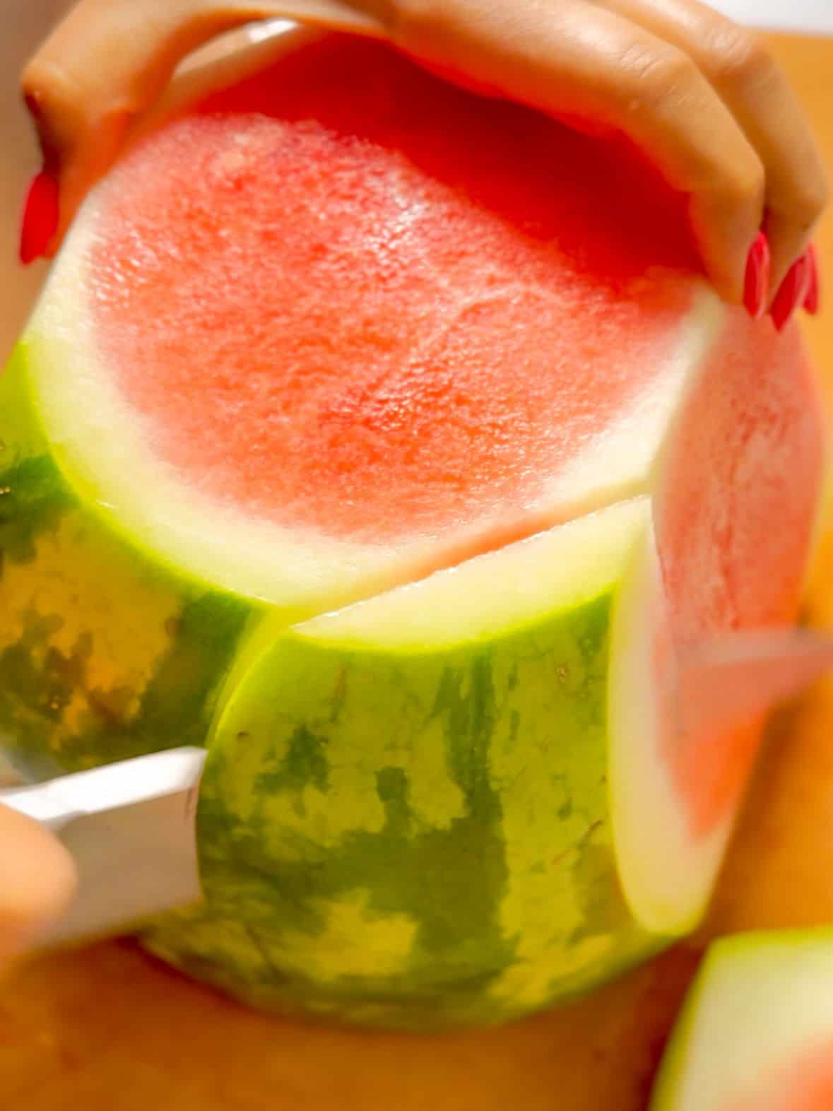 Start from the top and carefully slice downward following the curve of the fruit to remove the rind and the white flesh beneath it.