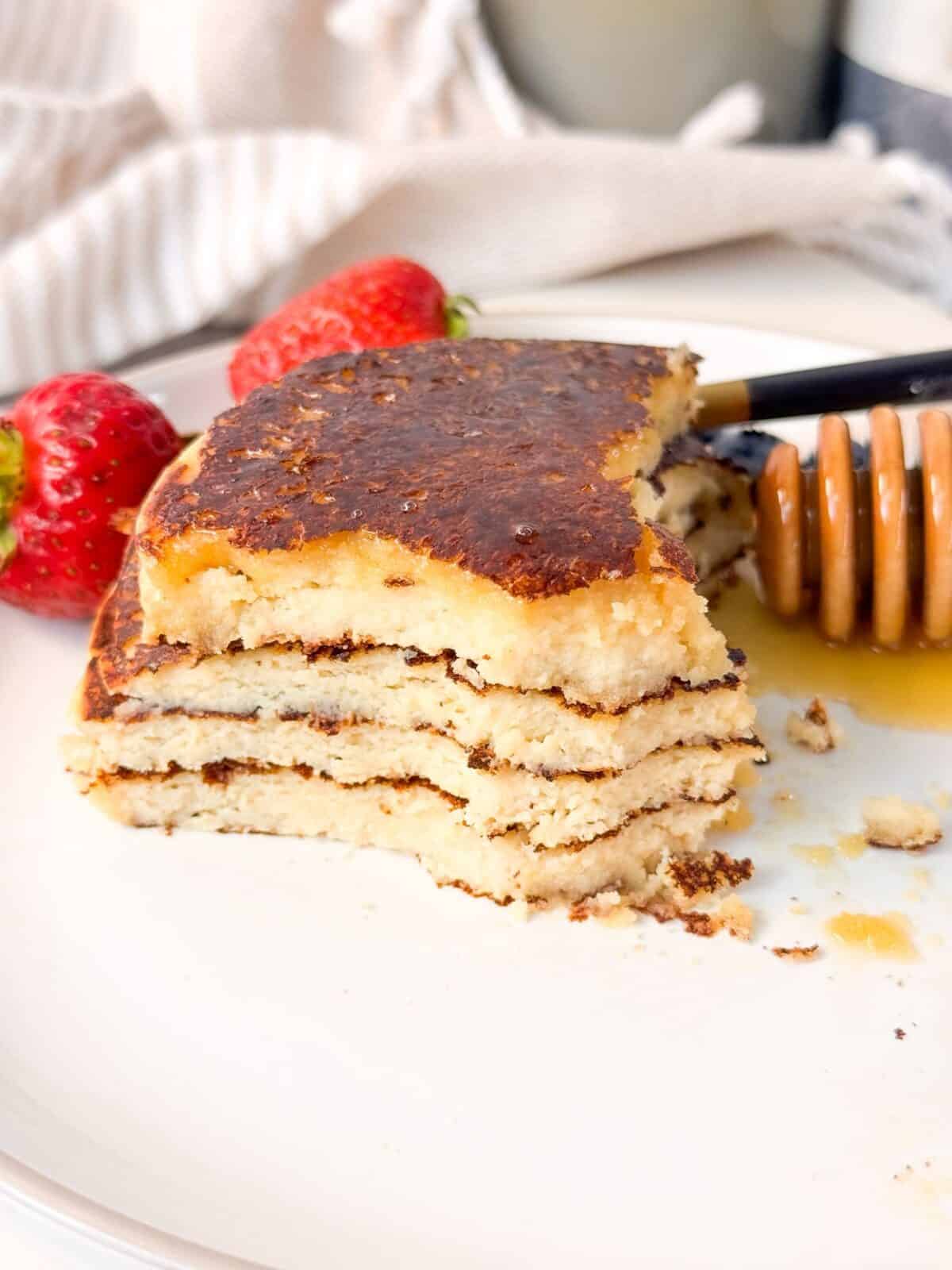 Gluten-Free Cottage Cheese Almond Flour Pancakes Close-up of fluffy cottage cheese almond flour pancakes with syrup and fresh berries.