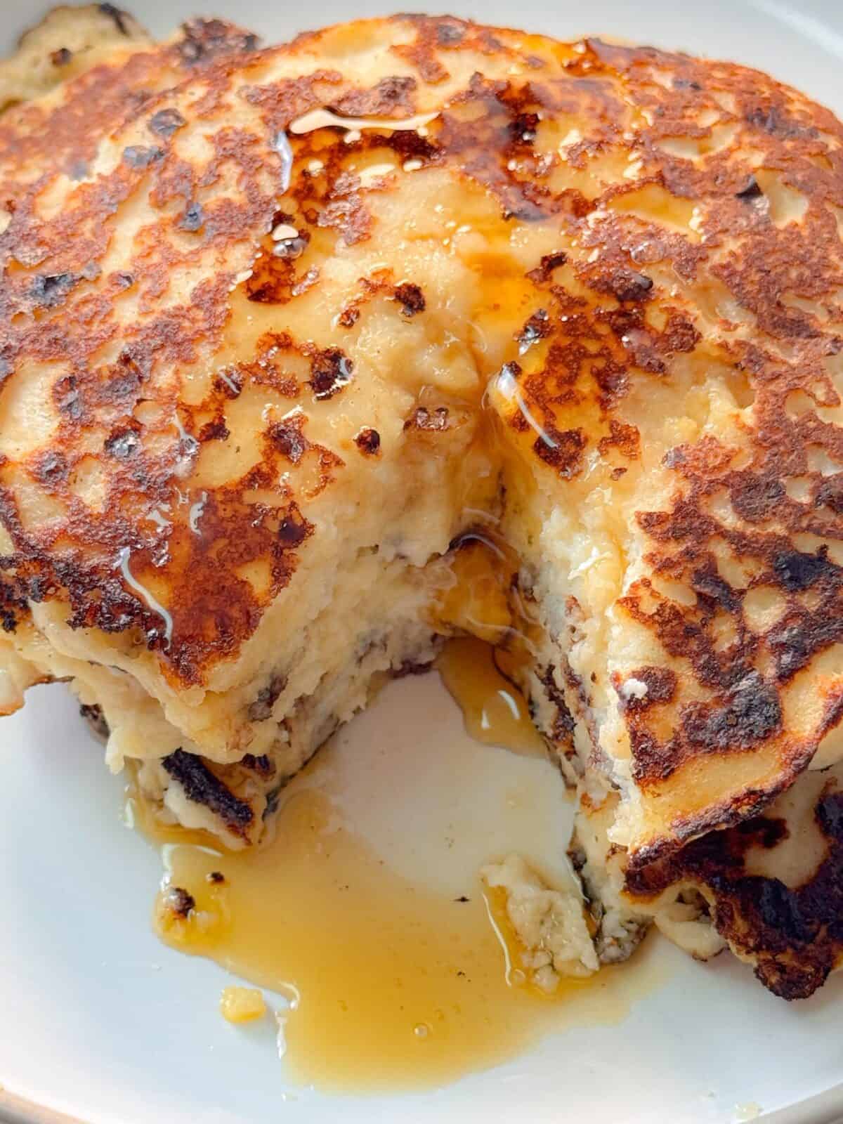Homemade Cottage Cheese Almond Flour Pancakes Close-up of thick pancake stack drizzled with syrup, showing moist and fluffy inside texture.