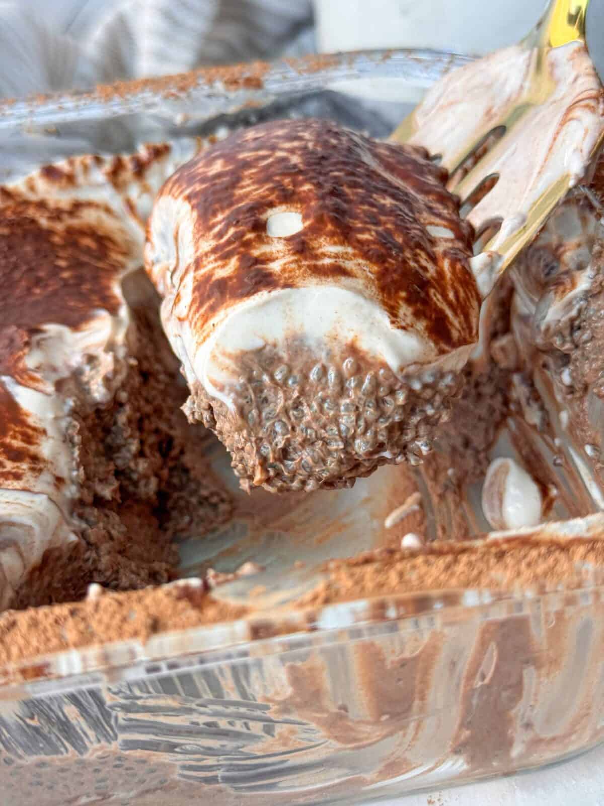 Indulgent Mocha Chia Pudding Cake Fork holding a bite of creamy mocha chia pudding cake with layers of chia, cocoa, and whipped topping.