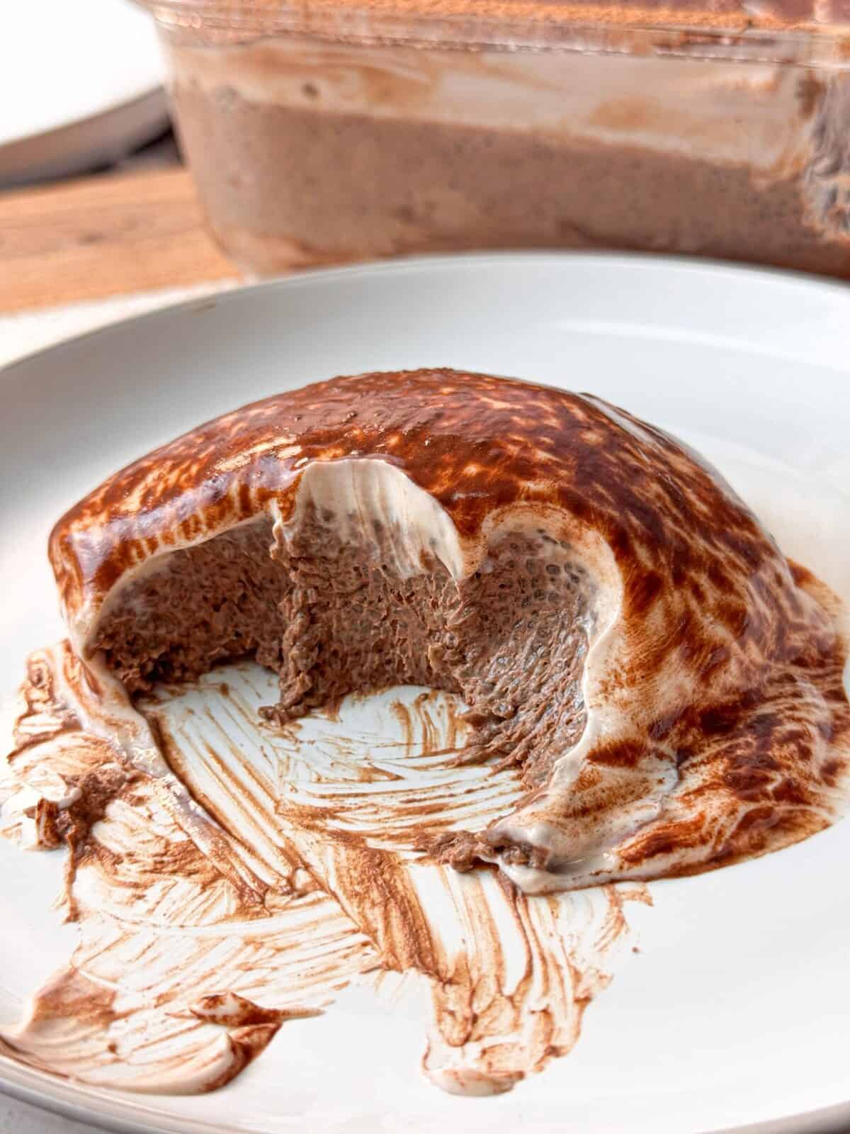 Light Mocha Chia Pudding Cake A close-up look at the mocha chia pudding cake, with bites taken out served on a white plate.