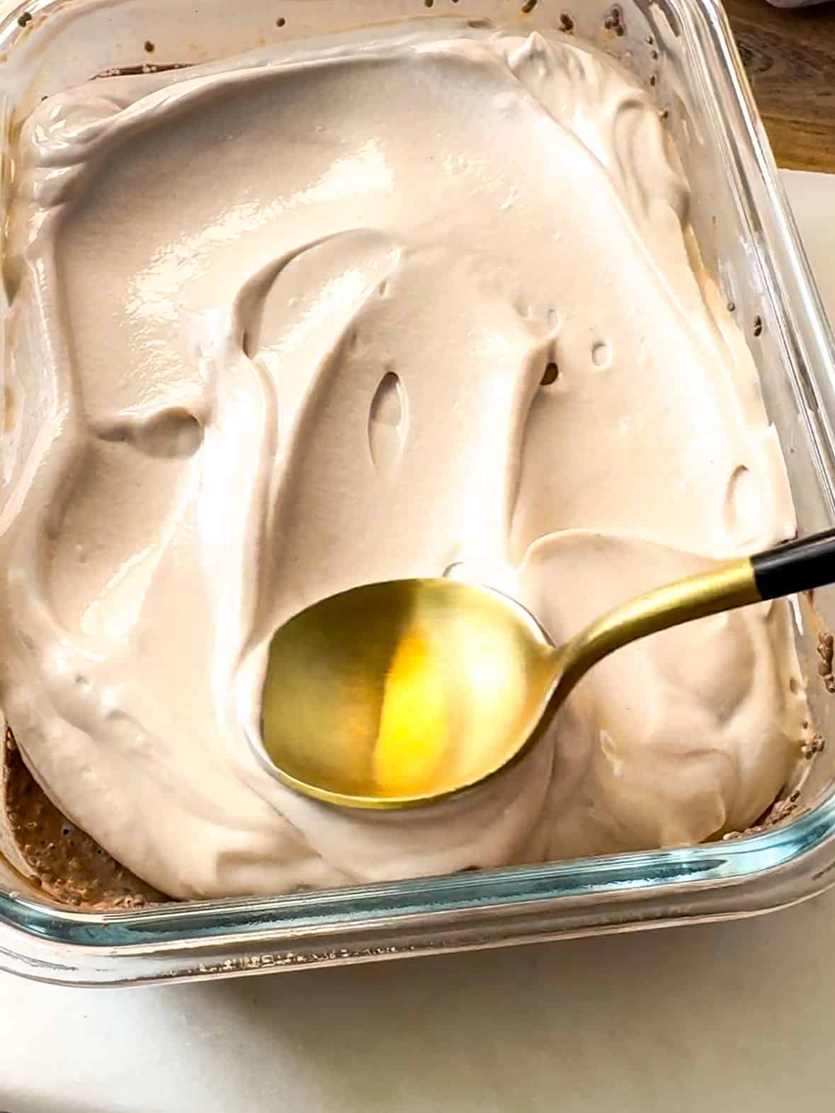 Make Mocha Chia Pudding Cake spreading the yogurt frosting evenly over the chia pudding layer