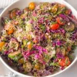 close-up of Mediterranean-style cucumber tomato feta salad with red cabbage, parsley, and sprouts dressed with and homemade vinaigrette dressing